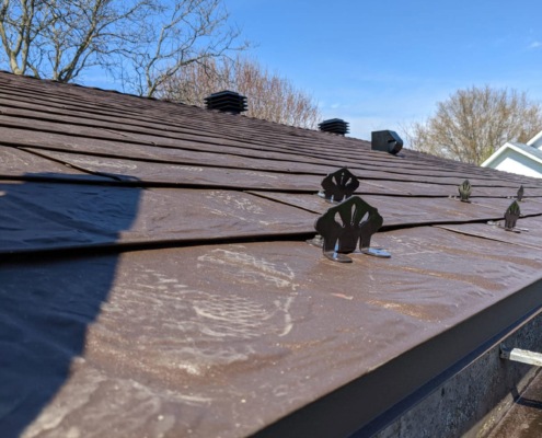 Snow guards installed on a brown metal roof in Wellesley, Ontario.